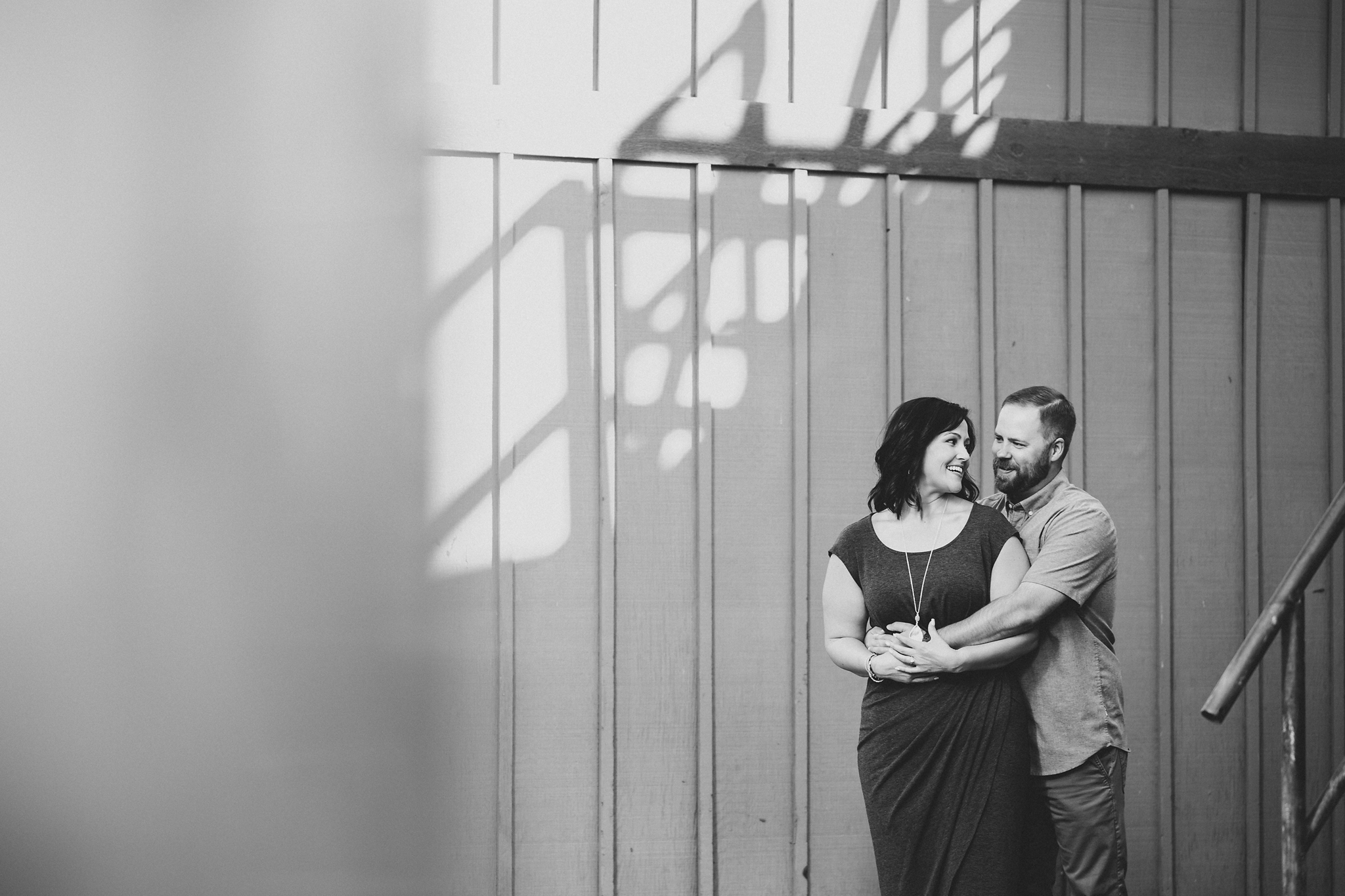 Engaged couple hugging in front of a large door at Treveri Cellars in Yakima