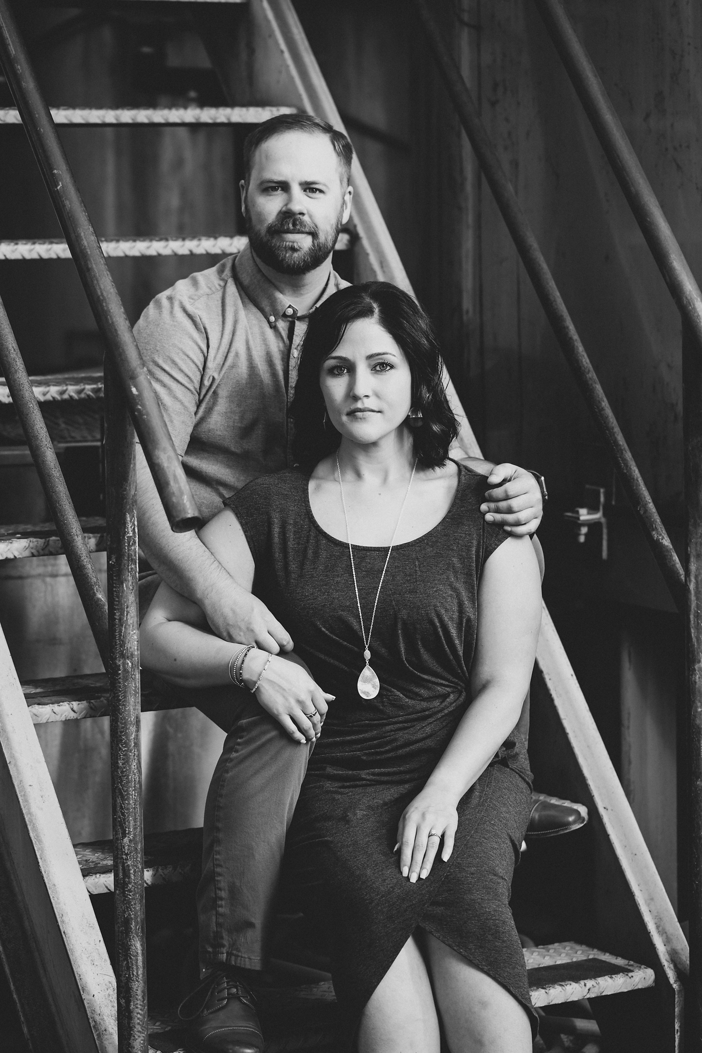 Engaged couple sitting on the stairs looking serious at Treveri Cellars in Yakima
